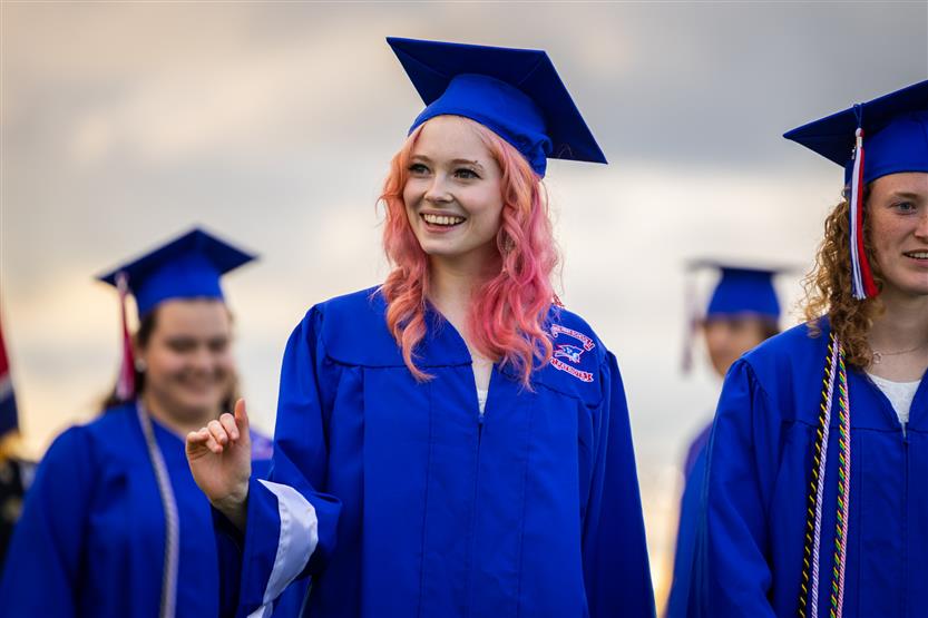 Students in blue robes graduate